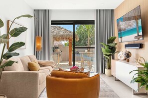 A modern living room with a sofa, a coffee table, and a TV mounted on the wall. - 5 Minutes to Eagle Beach|Private BBQ| Pool & Jacuzzi (Noord)