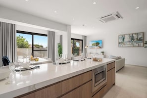 A modern kitchen with a central island, large windows, and a dining area with a view. - Private Pool | 2BR Retreat | Near Eagle Beach (Noord)
