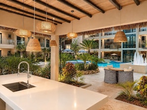 A pool area with a modern design, including a large sink, lounge chairs, and hanging lights. - Private Pool | 2BR Retreat | Near Eagle Beach (Noord)