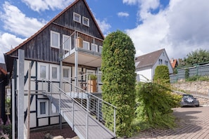 A two-story building with a balcony and a staircase leading to the upper floor.