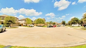A suburban street with houses, parked cars, and a clear sky. - 3 Bedrooms w/4 Beds | Home Theater | Massage Bed (Houston)