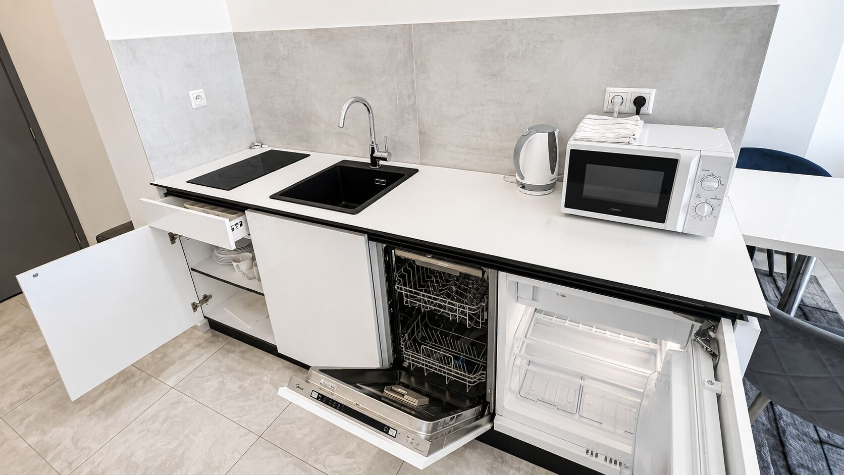 Cocina compacta con microondas, hervidor y lavavajillas integrado.
