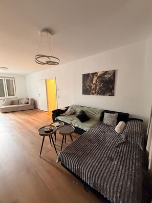A modern living room with a sofa set, a coffee table, and a painting on the wall. - Designer apartment with a 40 m² rooftop terrace – Achern, gateway to the Black Forest (Achern)