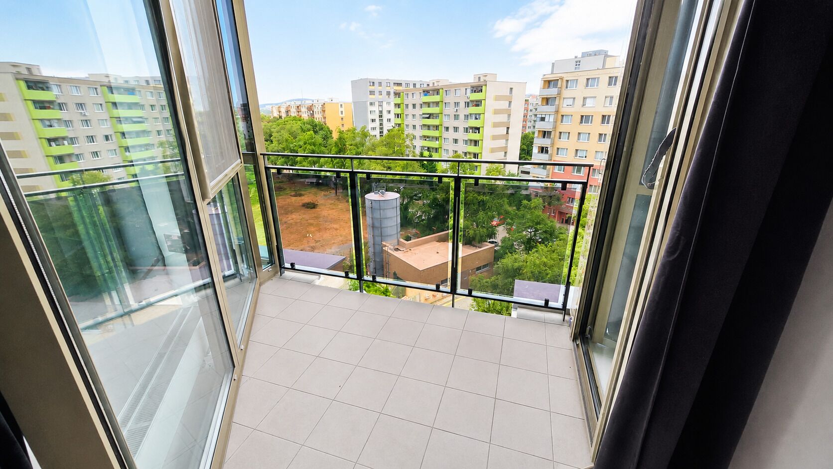 Un balcó amb vista a edificis i vegetació circumdants.