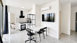 A modern kitchen with a microwave, oven, and black cabinetry. - 2 room Apartment with AC, Vienna Gate 4 (Bratislava)