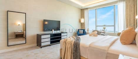 Une chambre d’hôtel moderne dotée d’un grand lit, d’un téléviseur à écran plat, d’un canapé, d’un coin repas et d’une grande fenêtre.