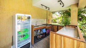 A compact kitchen with a built-in refrigerator, a sink, and a wooden countertop.