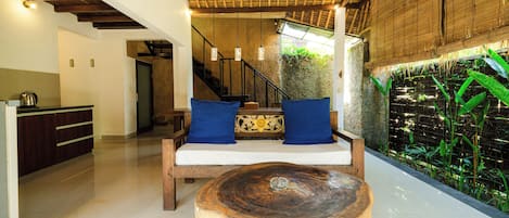 Una habitación con un banco de madera, una escalera y una pared con plantas verdes.