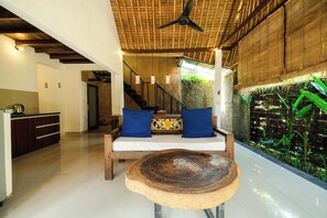 Una habitación con un banco de madera, una escalera y una pared con plantas verdes.
