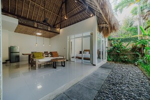 A modern interior with a dining area, a sofa, and a bed.