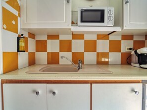 A kitchen with a sink, a microwave, and a coffee maker. - Ocean view, close to all amenities (Saint-François)