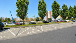 Ein Parkplatz mit markierten Stellplätzen und einem Gebäude im Hintergrund.