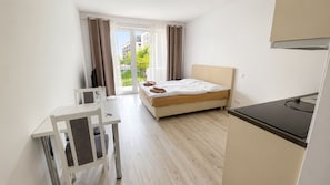 Ein modernes Hotelzimmer mit Bett, Schreibtisch und Blick ins Freie.