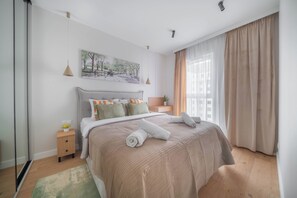 Une chambre à coucher avec un lit, une table de chevet et un tableau accroché au mur.