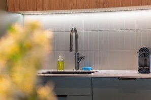 A kitchen with a stainless steel faucet, a soap dispenser, and a sponge on the counter. - Kierbedzia Prestige, Mokotów (Warszawa)
