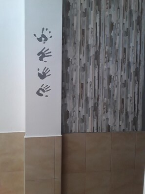 Een muur met een verticale strook handafdrukken en een reliëfpaneel.