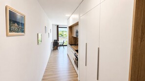 Eine moderne Küche mit weißen Schränken, einer Holz Arbeitsplatte und Blick ins Freie.