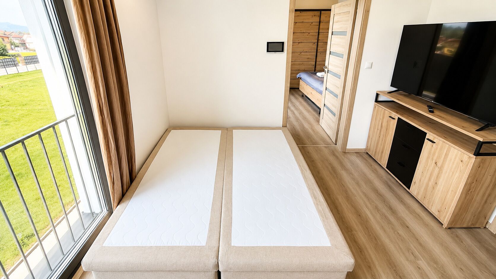 A room with a bed, a TV, and a wooden cabinet.