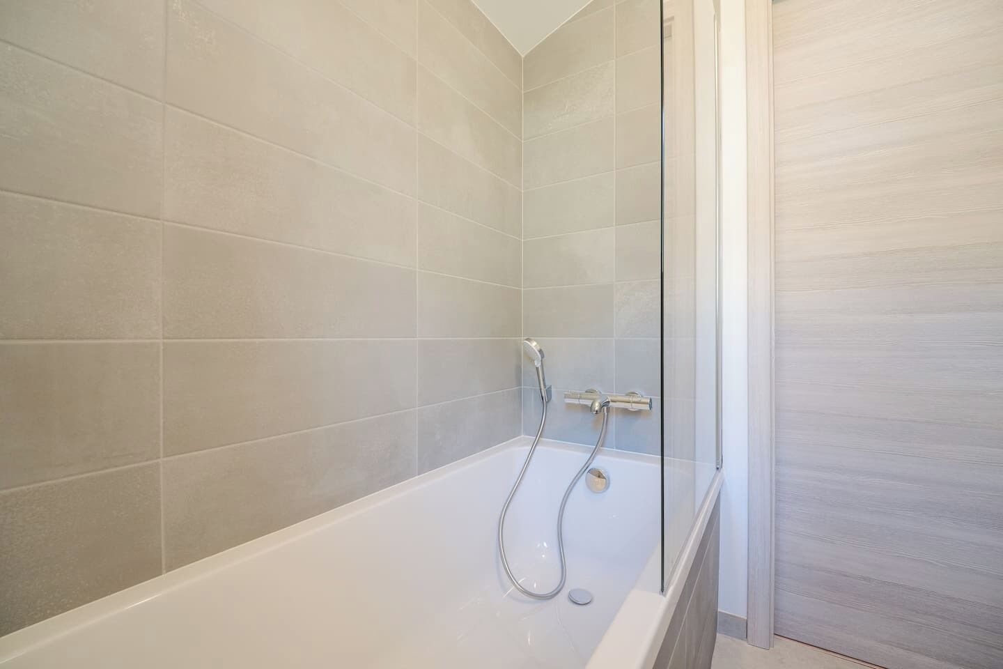 Une salle de bain équipée d’une baignoire, d’une douche et d’une paroi de douche en verre.