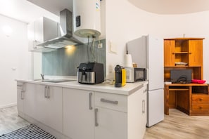 Eine kleine Küche mit eingebautem Herd, einer Kaffeemaschine und einer Mikrowelle.