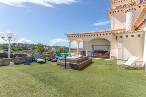 Eine Dachterrasse mit Sitzgelegenheiten im Freien, einem Whirlpool und Blick auf die umliegende Landschaft.