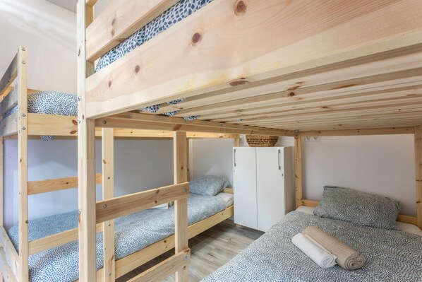 Ein Schlafzimmer mit Etagenbetten, einem Kleiderschrank und einem kleinen Schrank.