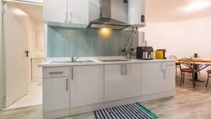 Une cuisine moderne dotée d’un îlot central, d’une cuisinière intégrée et d’un coin repas avec une table et des chaises.