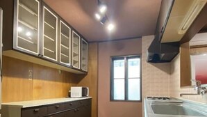Una cocina con armarios de madera, un microondas y un ventanal.