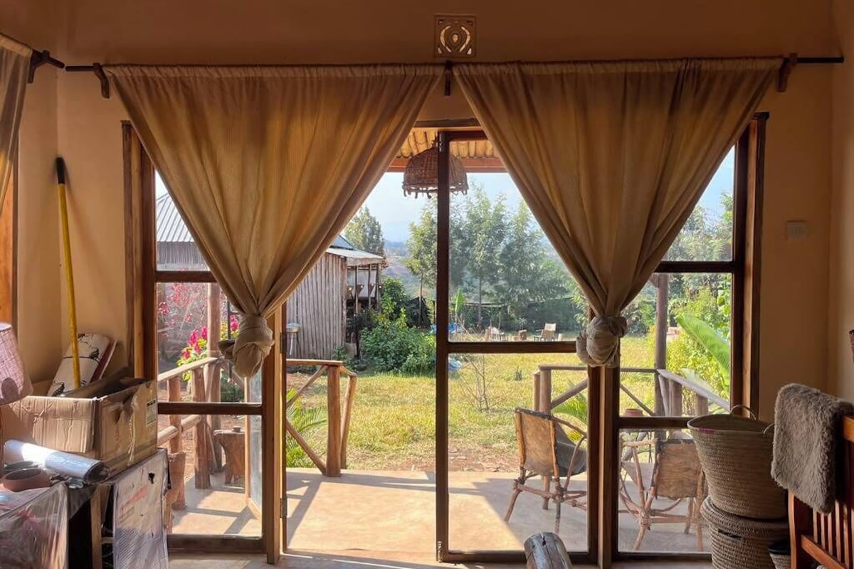 A room with large windows, wooden furniture, and a view of the outdoors.