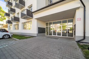 Moderni rakennus, jossa on päällystetty sisäänkäynti, lasiovet ja numero, joka osoittaa sisäänkäynnin.