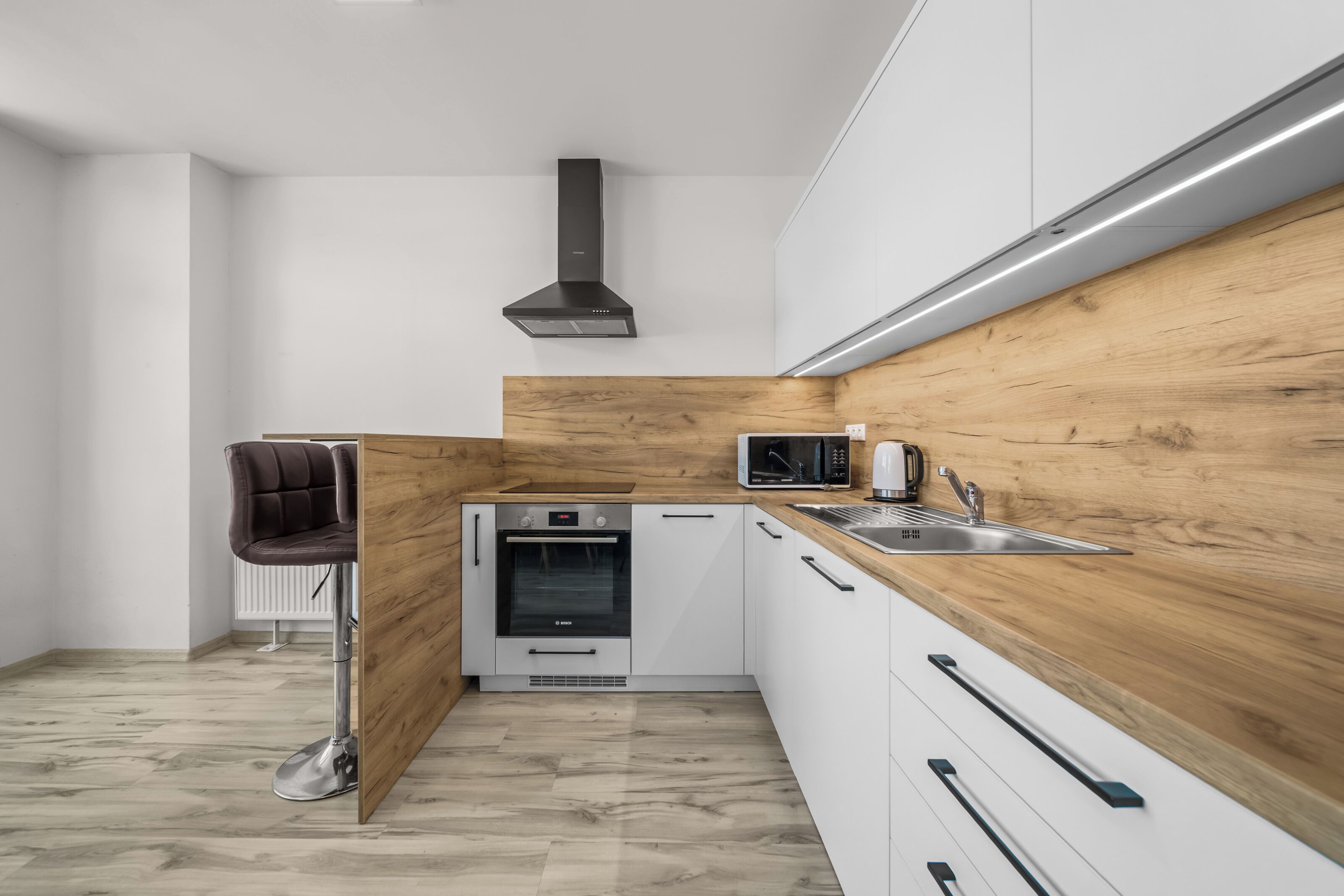 A modern kitchen with a Bosch oven, a microwave, and a sink.