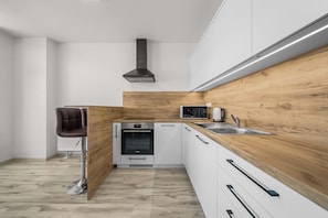 Eine moderne Küche mit Backofen von Bosch, einer Mikrowelle und einem Spülbecken.