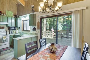 A kitchen with a central island, wooden cabinets, and a dining area with a table and chairs.