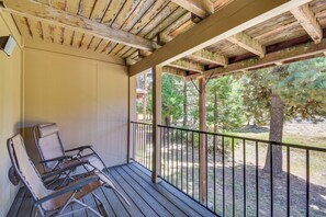 Ein überdachter Außenbereich mit Metallstühlen und einer Holzterrasse.