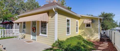 A single-story house with a front porch, a chimney, and a small attached garage.