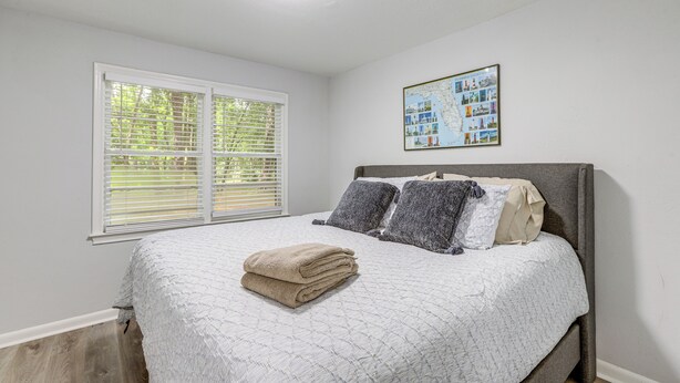 A bedroom with a bed, a window with blinds, a ceiling light, and a wall-mounted picture. - Walk to FSU Campus & Stadium! Tallahassee Home (Tallahassee)