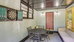 A room with a dartboard, a table with chairs, and a door. - Walk to FSU Campus & Stadium! Tallahassee Home (Tallahassee)
