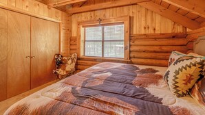 A log cabin bedroom with a bed, a window, and a ceiling fan. - 8 Mi to Ruidoso Downs! Family Cabin w/ Deck & Yard (Ruidoso)