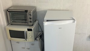 Una kitchenette equipada con microondas, tostadora y refrigerador.