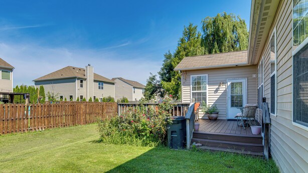 A residential property with a fenced backyard, a porch with outdoor seating, and a clear sky. - Modern Home w/ Private Deck & Yard in Indianapolis (Indianapolis)