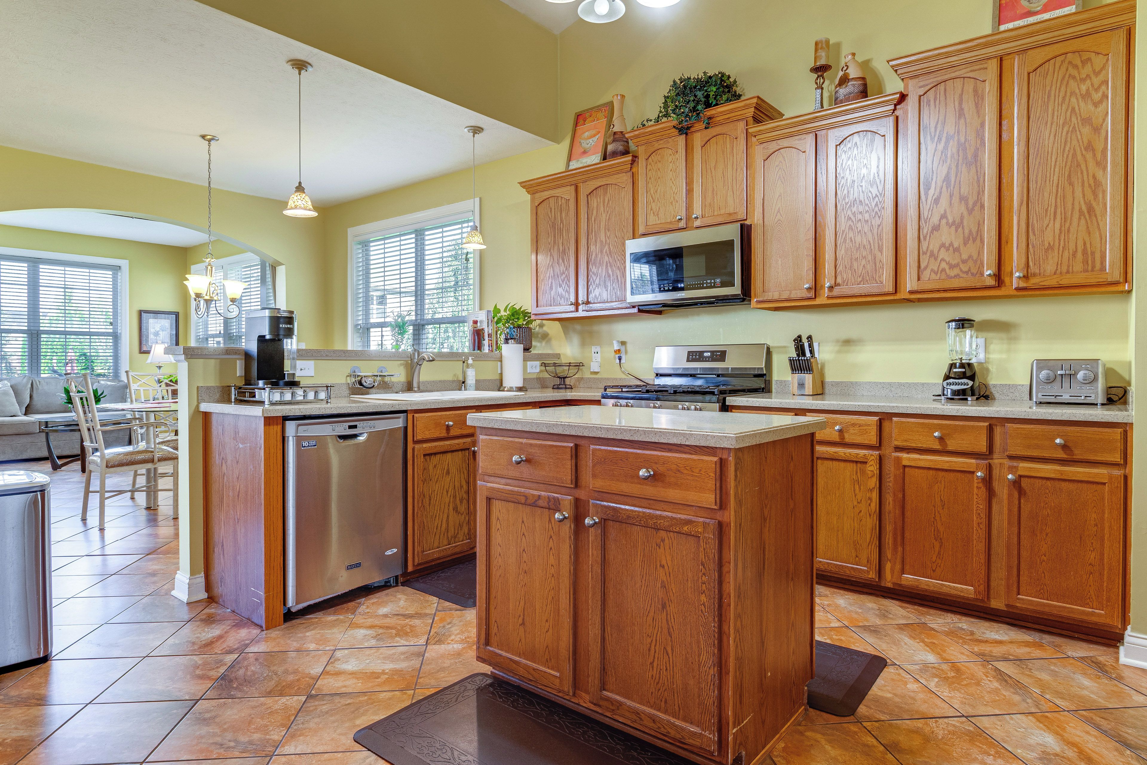 A kitchen with wooden cabinets, a dishwasher, a microwave, and a coffee maker.