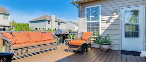 Une terrasse avec des meubles d’extérieur, un barbecue et une plante en pot.