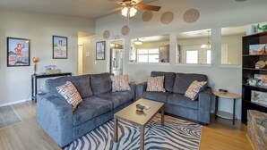 A living room with two grey sofas, a wooden coffee table, and a zebra-patterned rug. - Extended East Tulsa Home w/ Fenced Yard (Tulsa)
