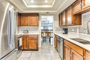 A kitchen with wooden cabinets, a stainless steel refrigerator, and a tiled backsplash. - Poolside Days! Condo 3 Mi to University of Arizona (Tucson)