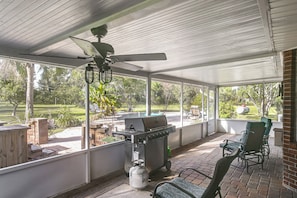 A covered patio area with a grill and seating.
