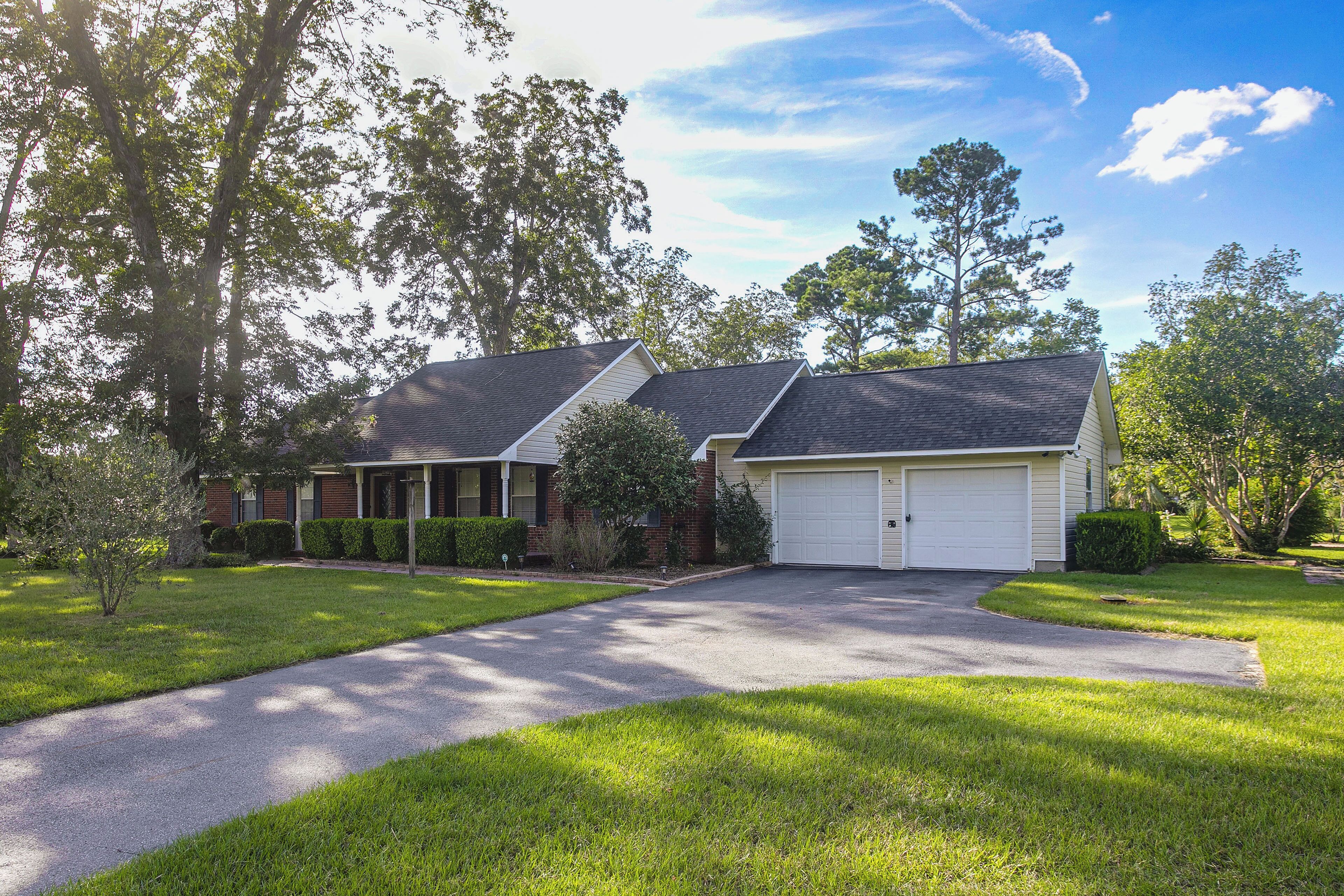 A two-story residential house with a front driveway, a garage, and a well-maintained lawn.
