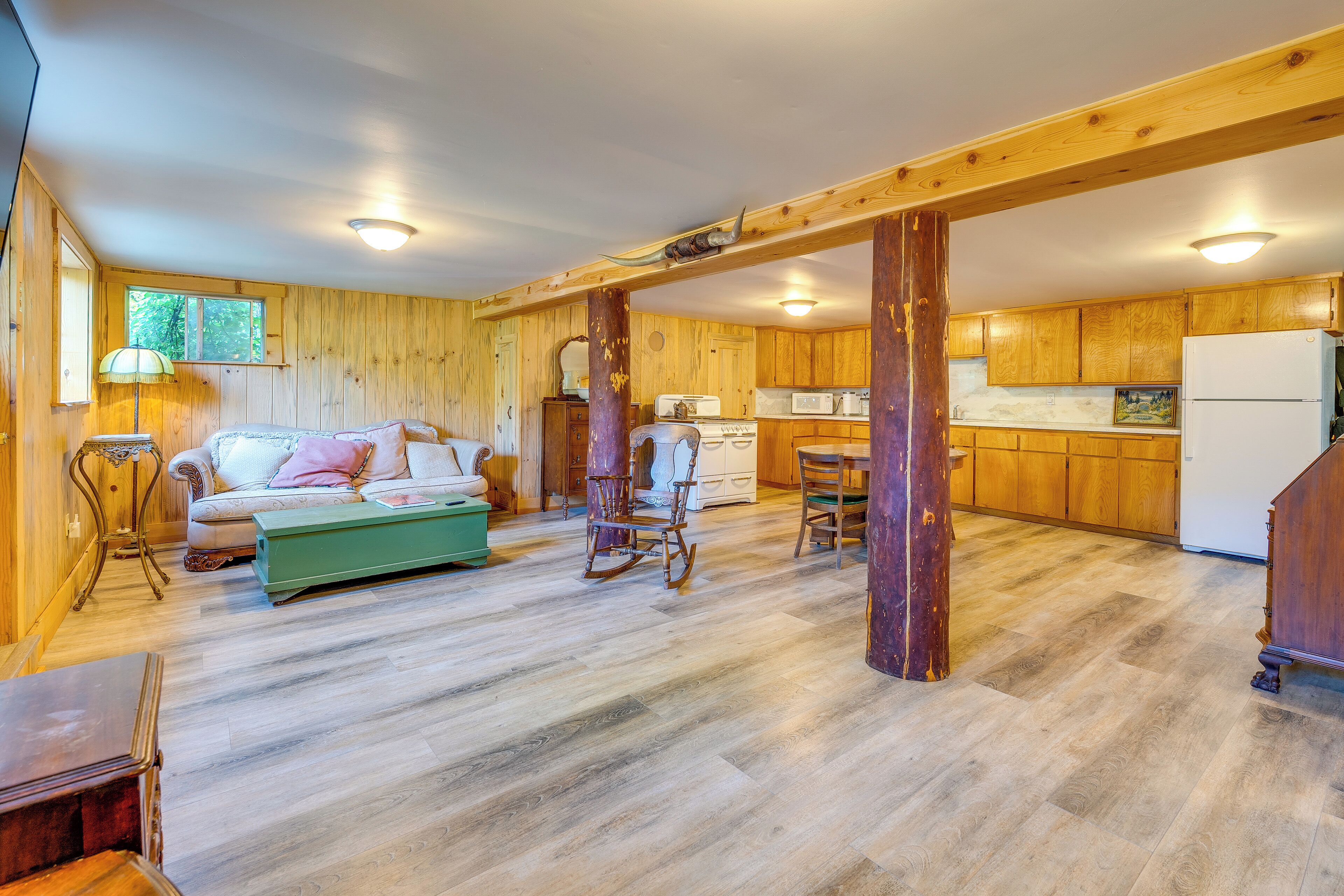 A spacious living area with a sofa, a rocking chair, and a dining table.