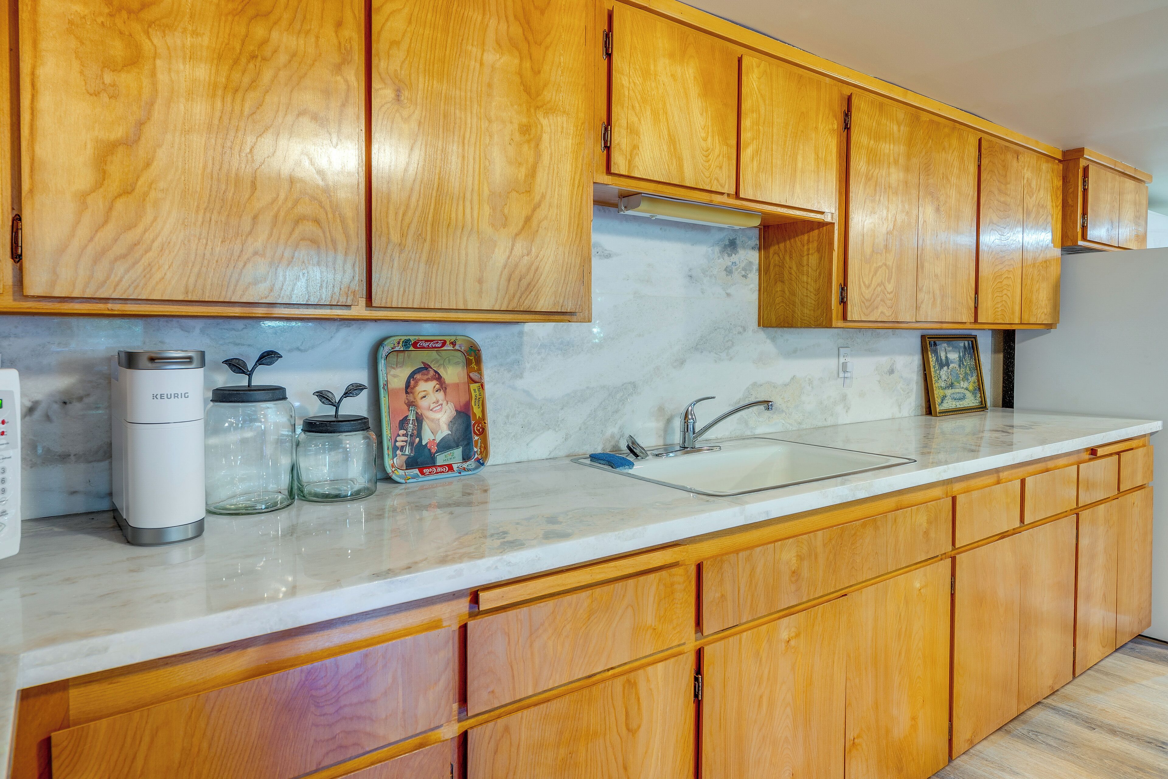 A kitchen with wooden cabinets, a built-in sink, and a coffee maker.