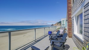 A balcony with a view of the beach and ocean, featuring two lounge chairs and a blue trash bin. - Direct Beach Access, 2 Mi to Chinook Winds Casino (Lincoln City)