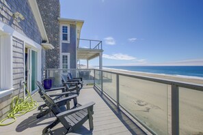 Ein Balkon mit Sitzgelegenheit und Blick auf den Strand.